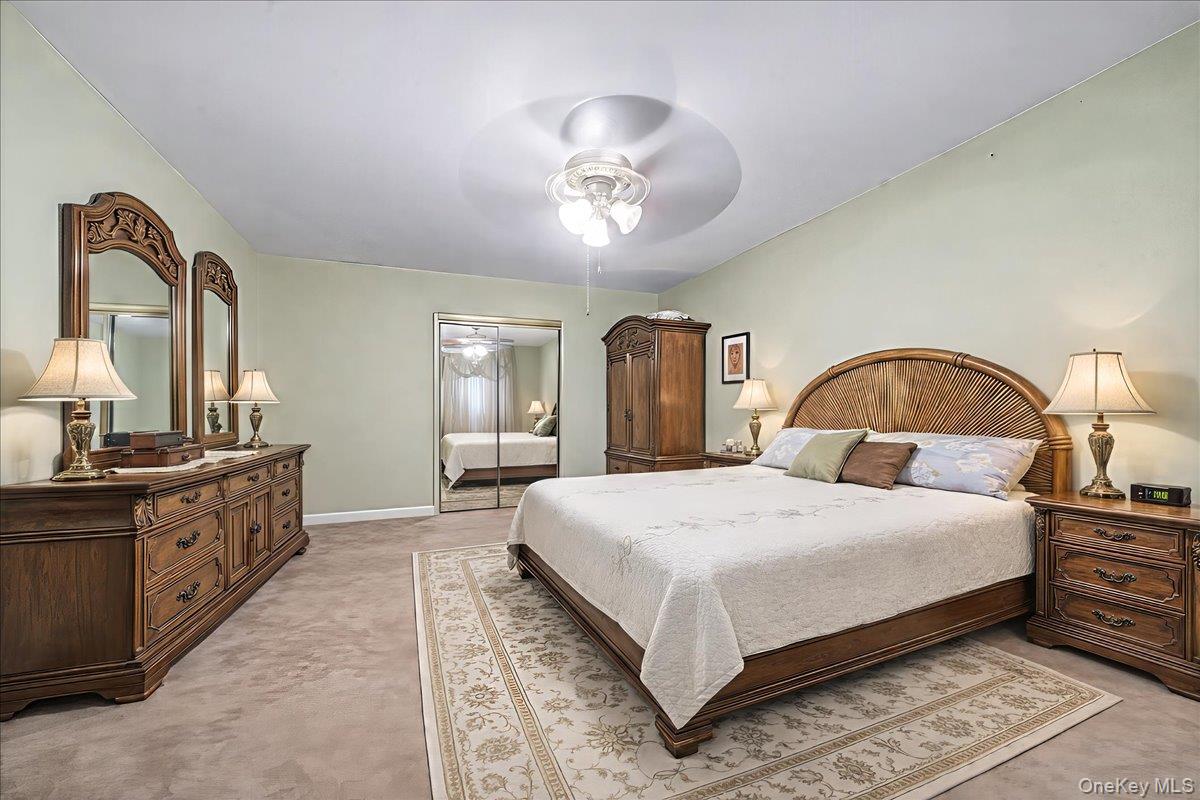 2715 Dewitt Place Bronx, NY 10469 - Photo 5 of 12 a spacious bedroom with a bed and a dresser with mirror
