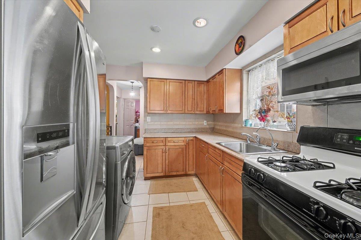 2715 Dewitt Place Bronx, NY 10469 - Photo 7 of 12 a kitchen with stainless steel appliances granite countertop a refrigerator stove and sink