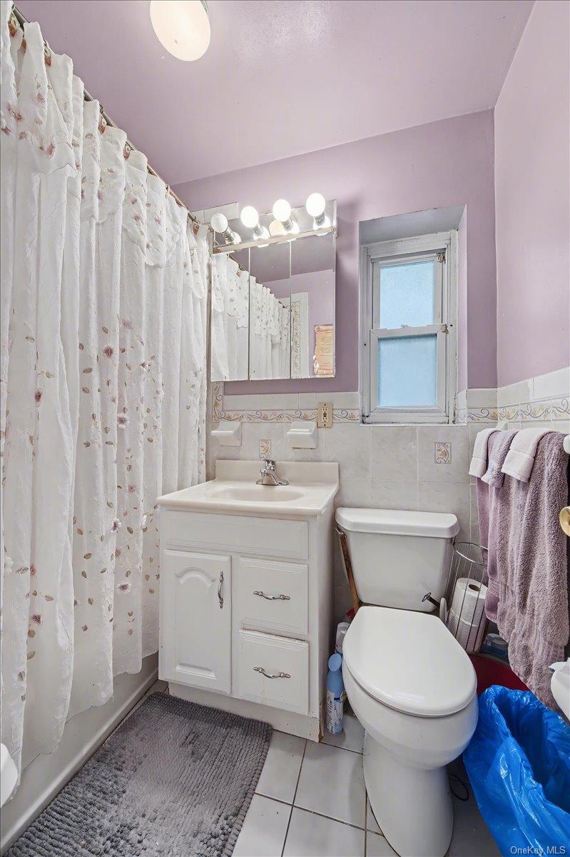 2715 Dewitt Place Bronx, NY 10469 - Photo 9 of 12 a bathroom with a sink a toilet a mirror a vanity and shower