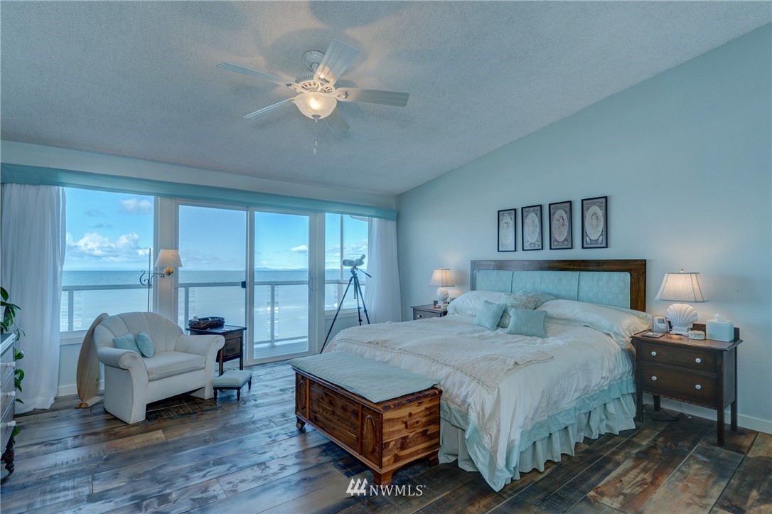 2575 West Beach Road Oak Harbor, WA 98277 - Photo 13 of 25 a bedroom with a large bed and a chandelier