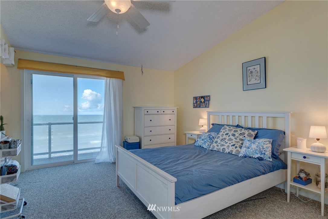 2575 West Beach Road Oak Harbor, WA 98277 - Photo 16 of 25 a bedroom with a bed and a chandelier