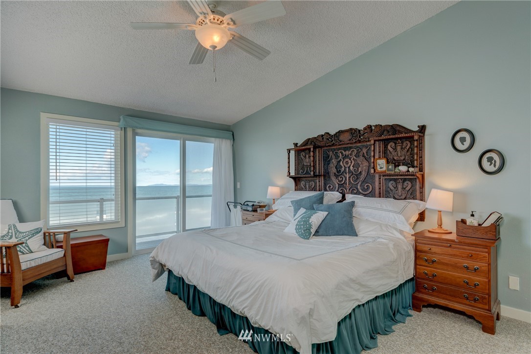 2575 West Beach Road Oak Harbor, WA 98277 - Photo 20 of 25 a bedroom with a bed and a chandelier