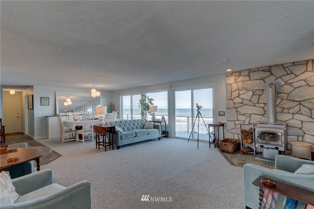 2575 West Beach Road Oak Harbor, WA 98277 - Photo 6 of 25 a living room with furniture a fireplace and large windows