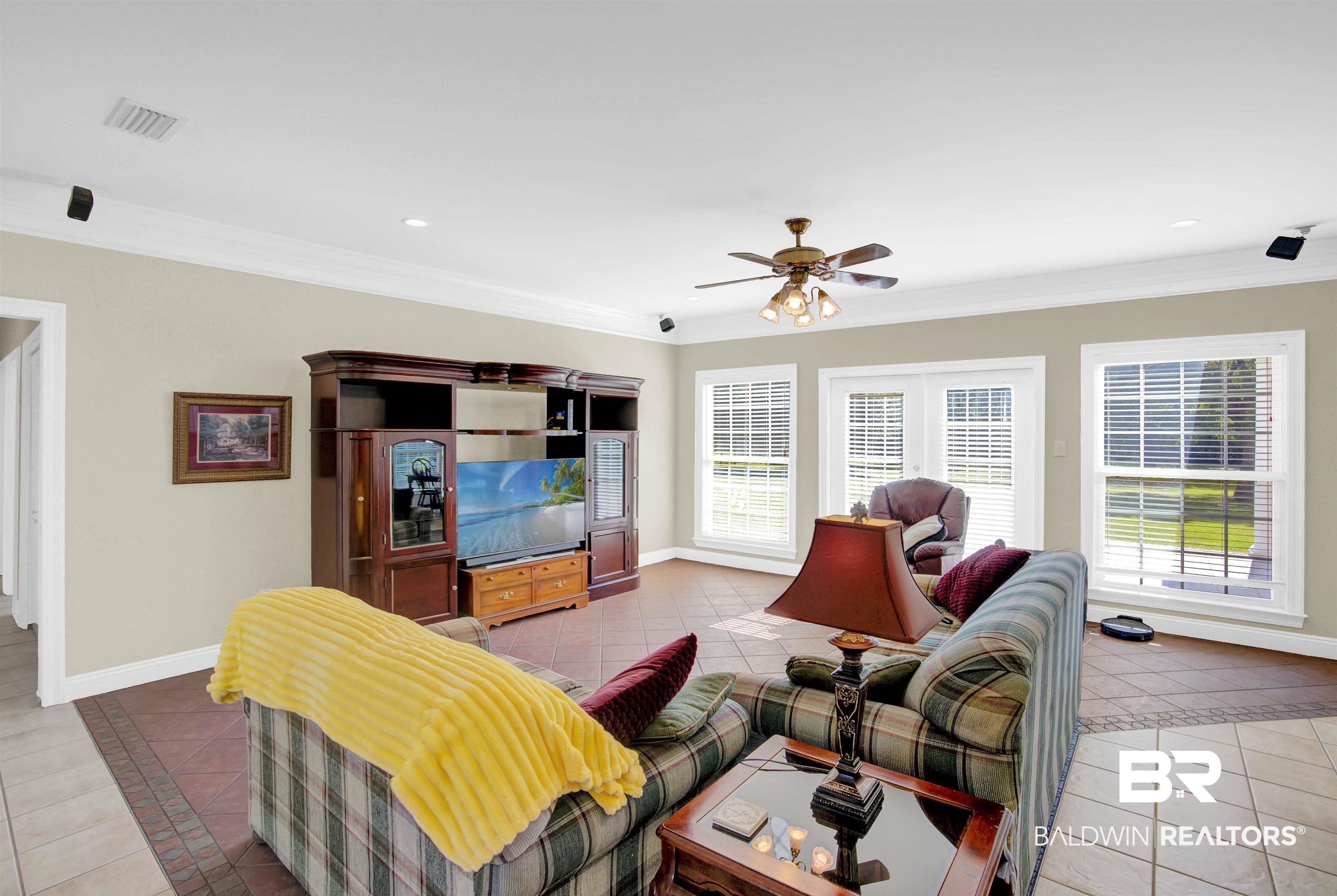 27688 Rigsby Road Daphne, AL 36526 - Photo 14 of 56 Living room featuring ceiling fan, crown molding, and tile patterned flooring