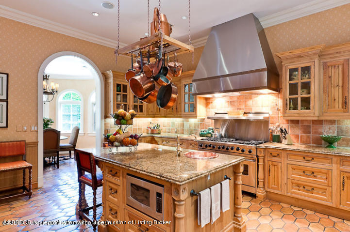 230 Wells Road Palm Beach, FL 33480 - Photo 7 of 9 a kitchen with a stove a sink a dining table and chairs