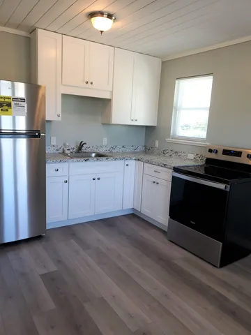 a kitchen with granite countertop a sink stove and refrigerator
