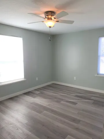 wooden floor in an empty room with a window