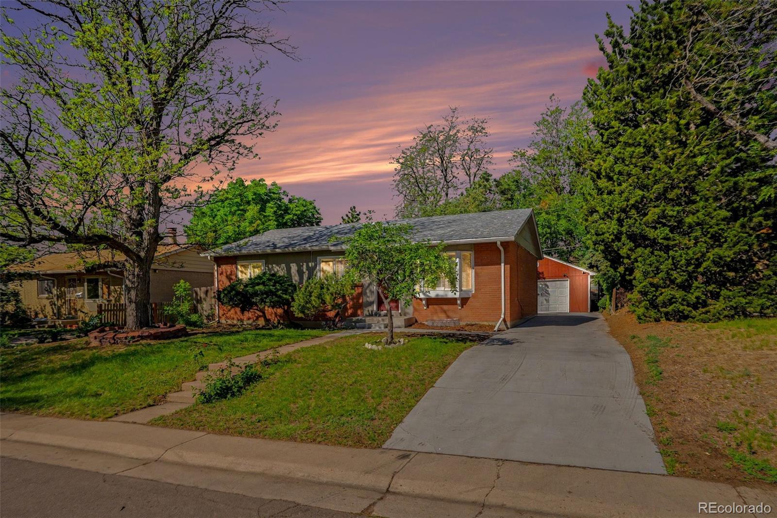 3217 South Stuart Street Denver, CO 80236 - Photo 1 of 29 a front view of a house with a yard and trees