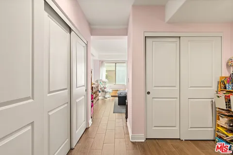 a view of a hallway with closet and wooden floor