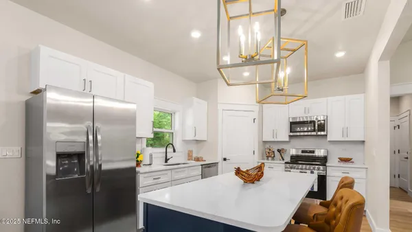 a kitchen with stainless steel appliances granite countertop a sink a stove cabinets and a window