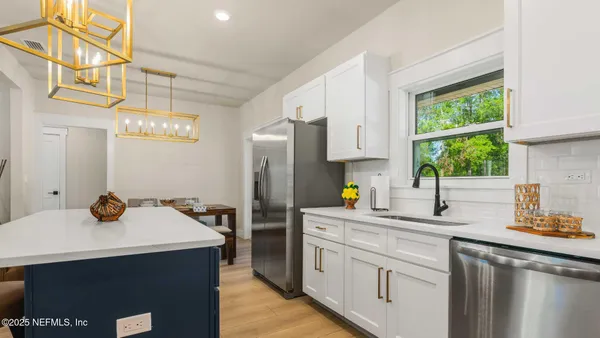a kitchen with a cabinets appliances and a dining table