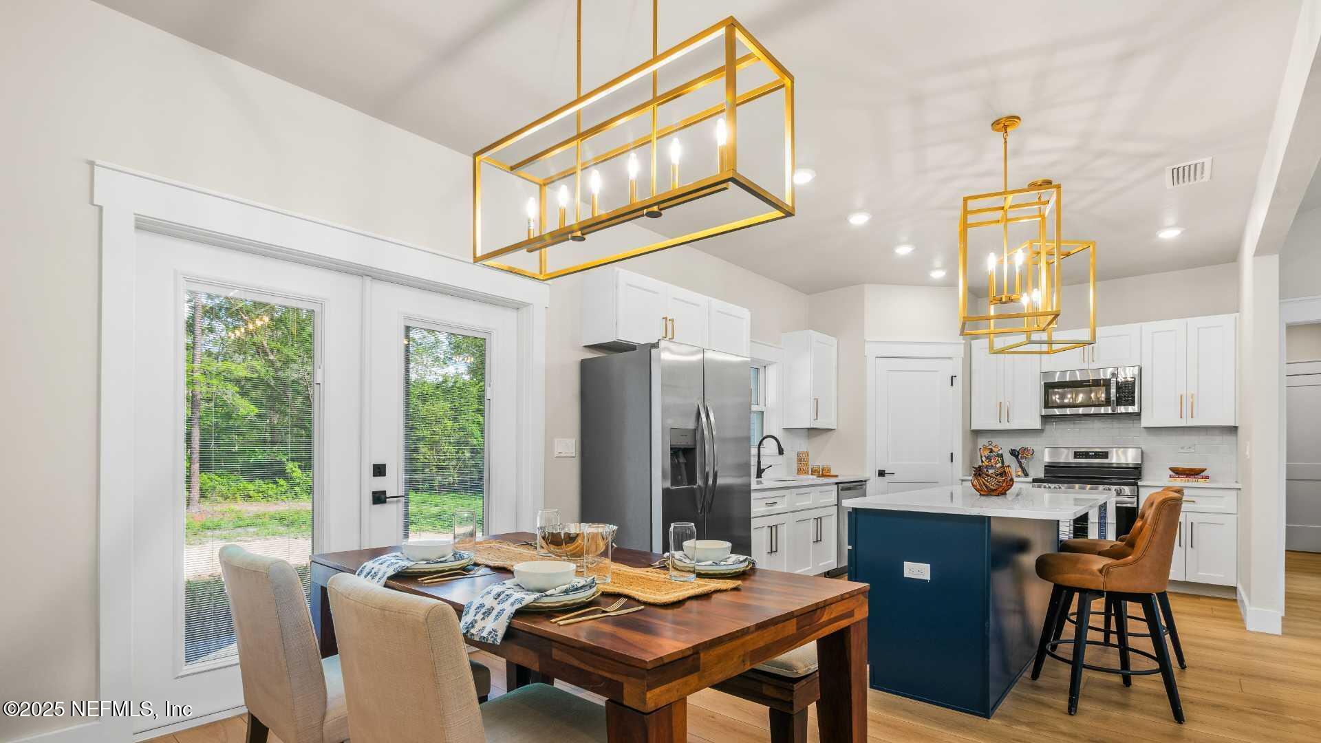 10055 Fox Hollow Drive Hampton, FL 32044 - Photo 15 of 54 a open dining room with stainless steel appliances kitchen island granite countertop a table chairs and a view of living room