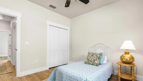 a bedroom with a bed and wooden floor