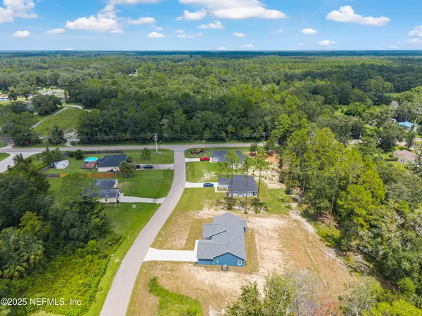 an aerial view of residential houses with outdoor space and street view