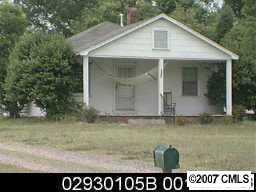 a view of a small house with a yard