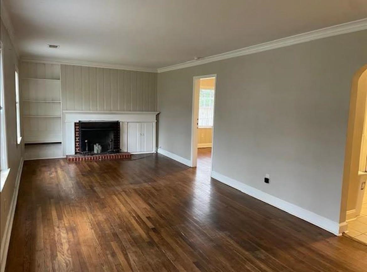 766 Buck Street Memphis, TN 38111 - Photo 2 of 12 an empty room with wooden floor and fireplace