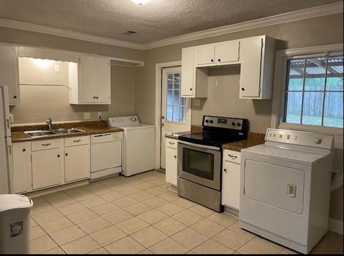 766 Buck Street Memphis, TN 38111 - Photo 3 of 12 a kitchen with white cabinets and white appliances