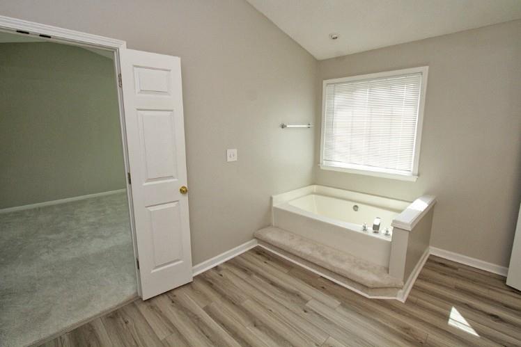 11700 Bentham Court Alpharetta, GA 30005 - Photo 14 of 21 a bathroom with a tub a sink and a shower