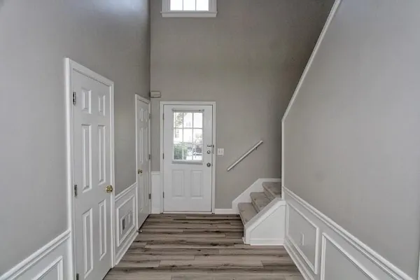 a view of a hallway with wooden floor and staircase