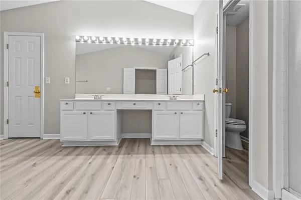 a spacious bathroom with a tub double sink and a mirror