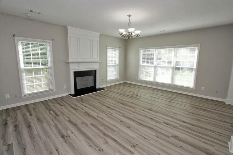 11700 Bentham Court Alpharetta, GA 30005 - Photo 3 of 21 a view of an empty room with wooden floor fireplace and a window