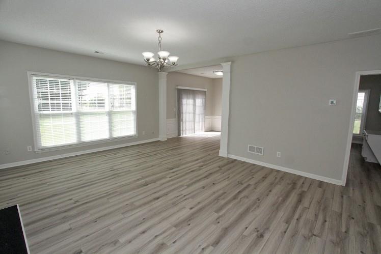 11700 Bentham Court Alpharetta, GA 30005 - Photo 4 of 21 a view of an empty room with wooden floor and a window