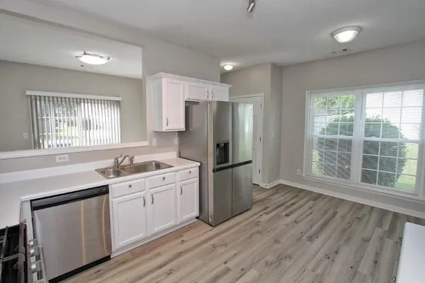 a kitchen with a sink a refrigerator and window