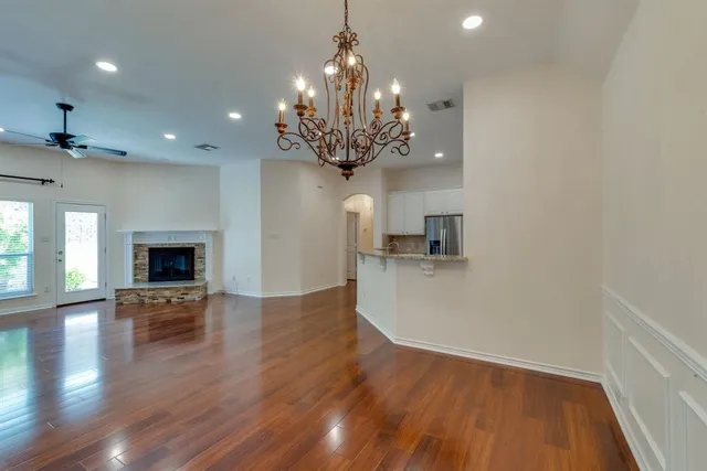 a view of a room with wooden floor and a chandelier