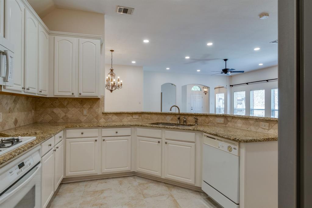 7728 Lancaster Gate Frisco, TX 75035 - Photo 23 of 30 a kitchen with white cabinets sink and stove