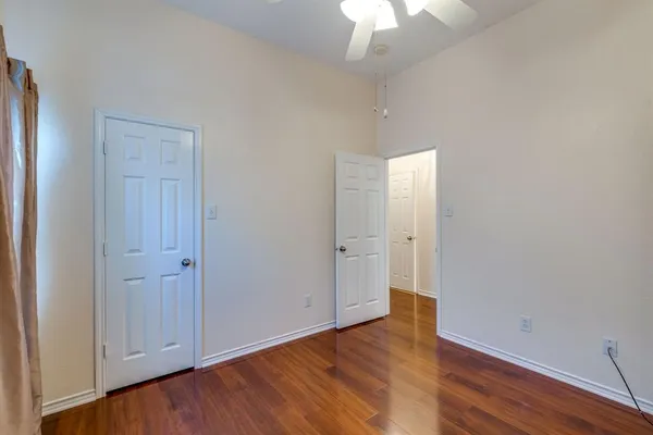 an empty room with wooden floor and closet area