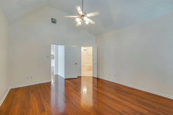 a view of an empty room with wooden floor