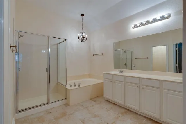 a spacious bathroom with a double vanity sink a mirror and a bathtub