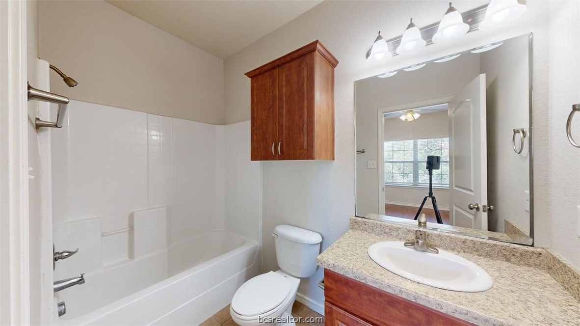 4453-4455 Reveille Road College Station, TX 77845 - Photo 14 of 37 a bathroom with a granite countertop sink toilet and shower
