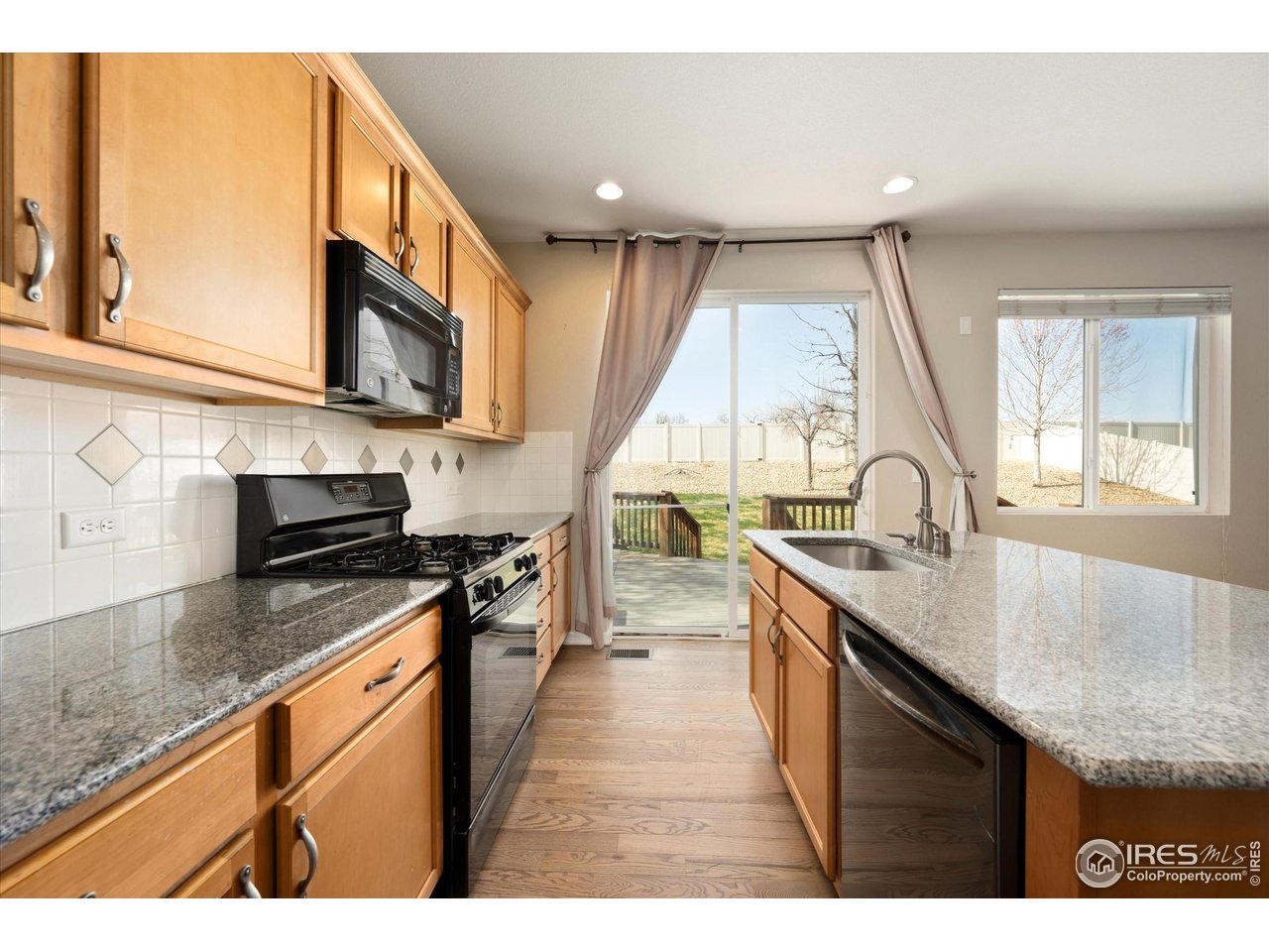 4874 Sandy Ridge Avenue Firestone, CO 80504 - Photo 4 of 35 a kitchen with stainless steel appliances granite countertop a sink a stove top oven a counter space and cabinets