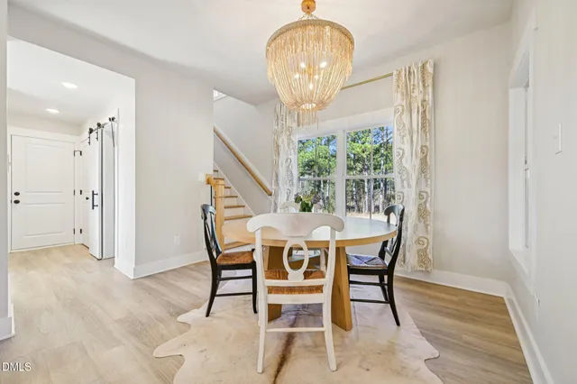 a view of a dining room with furniture wooden floor and chandelier