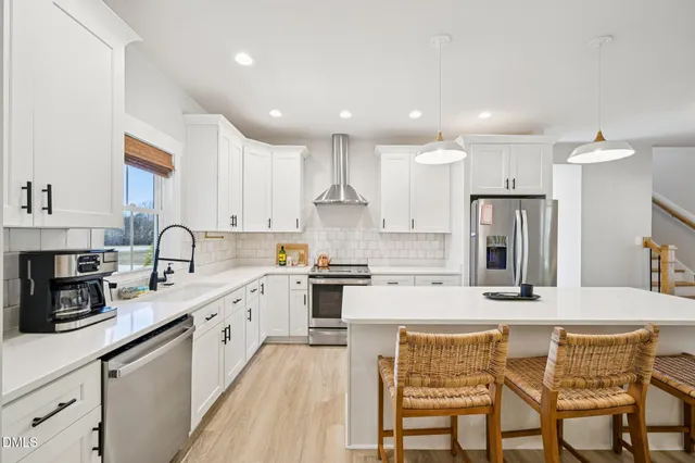 a kitchen with refrigerator a sink and chairs