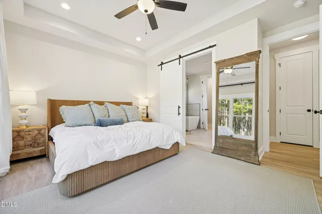 a spacious bedroom with a bed and a chandelier