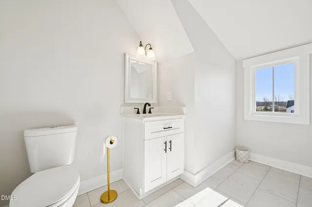 a bathroom with a sink mirror vanity and toilet