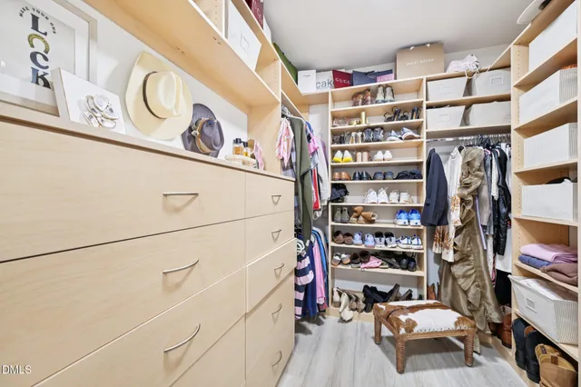 a view of walk in closet with clothes and shoes