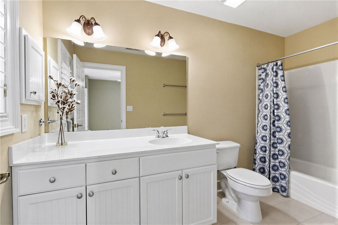 204 Butler Avenue Greenville, SC 29601 - Photo 19 of 26 White cabinetry and countertops define this well-appointed bathroom space.