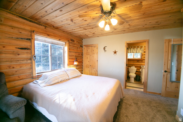 348 North Jakes Pl Road Loa, UT 84747 - Photo 8 of 26 Carpeted bedroom with log walls, wood ceiling, ceiling fan, and connected bathroom