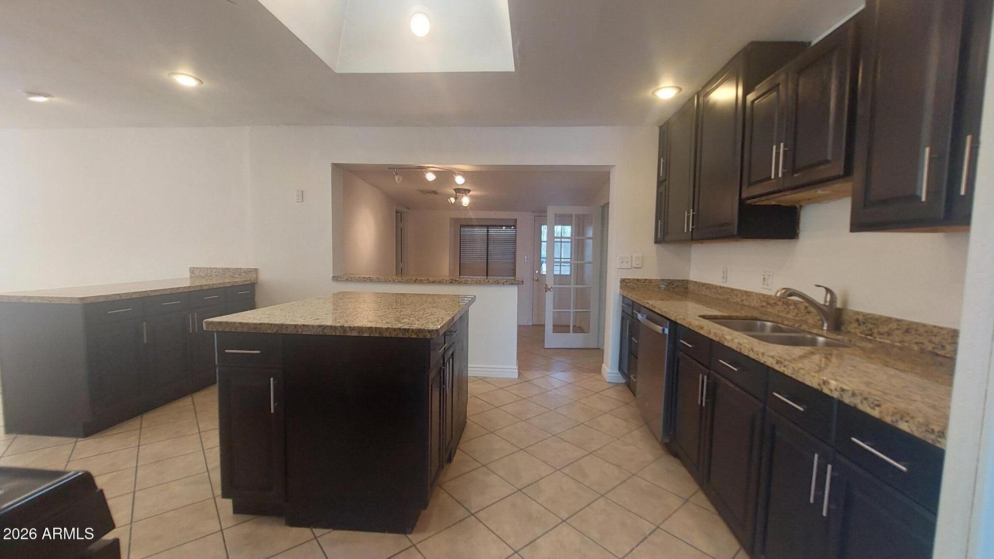 2448 West Freeway Lane Phoenix, AZ 85021 - Photo 11 of 27 a kitchen with granite countertop a sink a stove top oven and cabinets