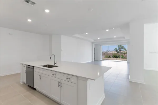 a kitchen with stainless steel appliances a refrigerator sink and white cabinets