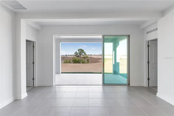 an empty room that has a large window and front door
