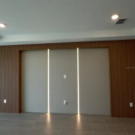 an empty room with wooden floor and closet area