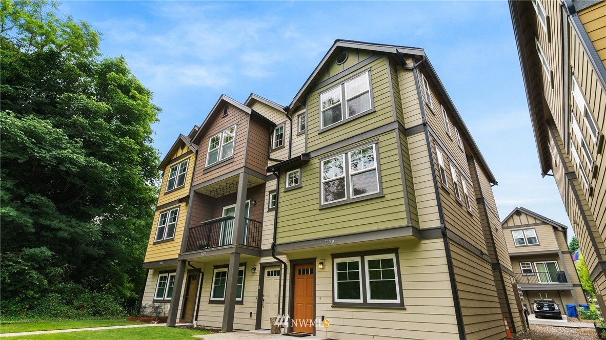 7170 Shinkle Place Southwest Seattle, WA 98106 - Photo 1 of 29 a front view of a residential apartment building with a yard