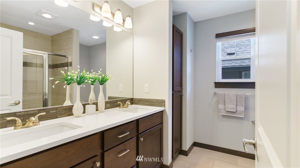 7170 Shinkle Place Southwest Seattle, WA 98106 - Photo 20 of 29 a bathroom with a double vanity sink a mirror and a shower