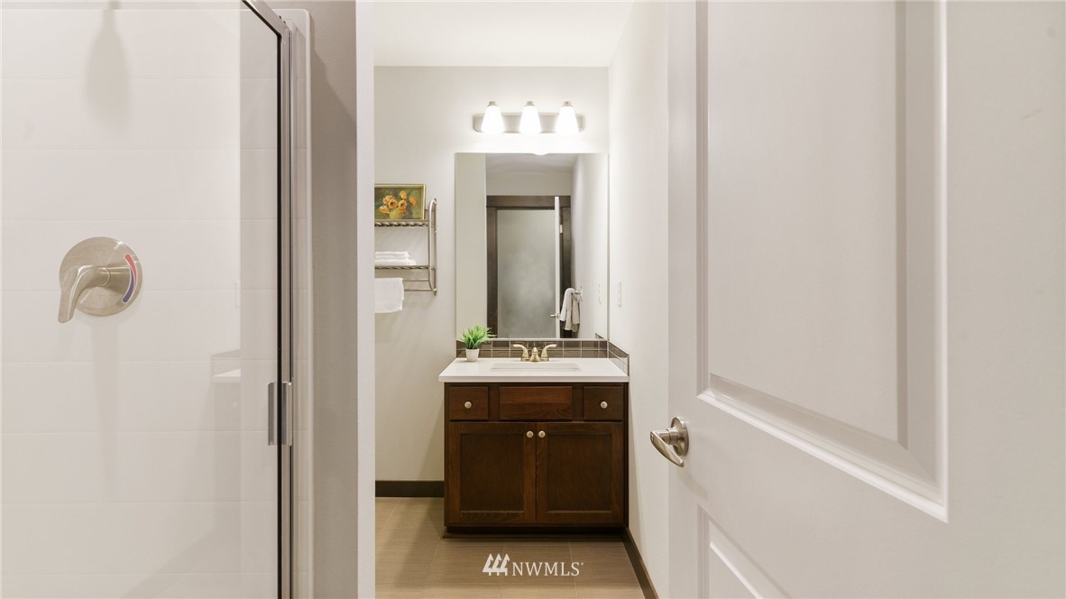 7170 Shinkle Place Southwest Seattle, WA 98106 - Photo 6 of 29 a bathroom with a sink and mirror with shower