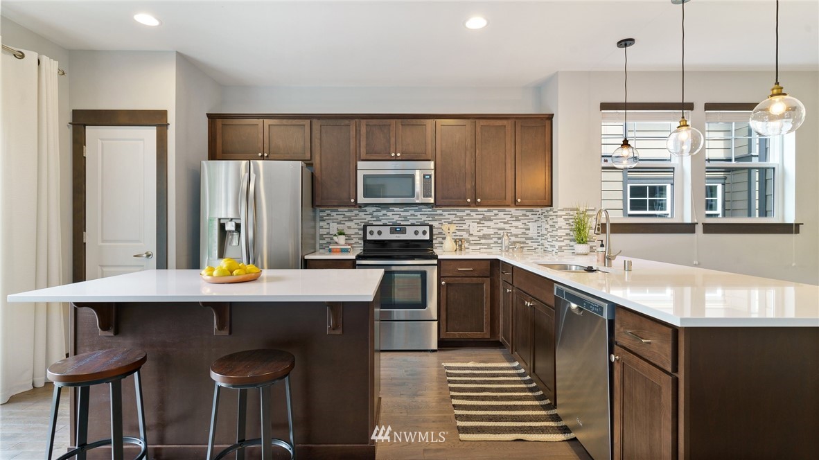 7170 Shinkle Place Southwest Seattle, WA 98106 - Photo 7 of 29 a kitchen with stainless steel appliances a sink stove and refrigerator