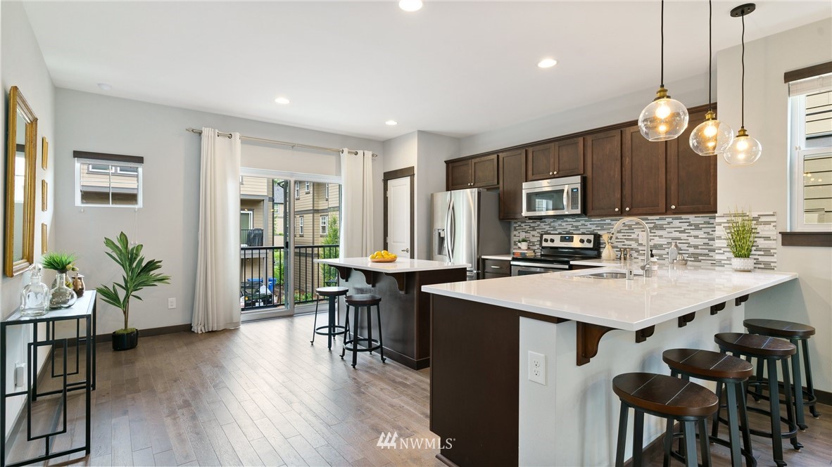 7170 Shinkle Place Southwest Seattle, WA 98106 - Photo 8 of 29 a large kitchen with kitchen island a dining table chairs and a large window